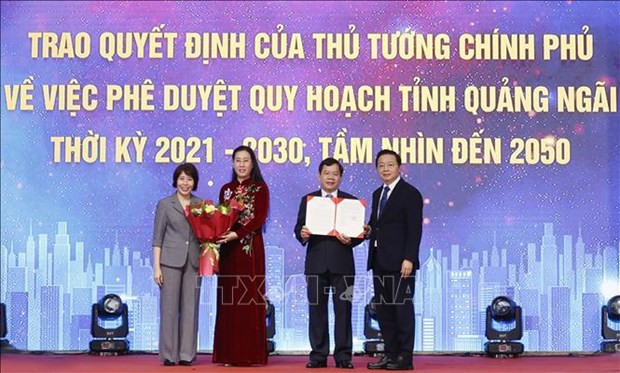 Deputy Prime Minister Tran Hong Ha (R) presents the Prime Minister's Decision approving the Master Plan of Quang Ngai province for 2021 - 2030, with a vision to 2050, to a local representative. (Photo: VNA)