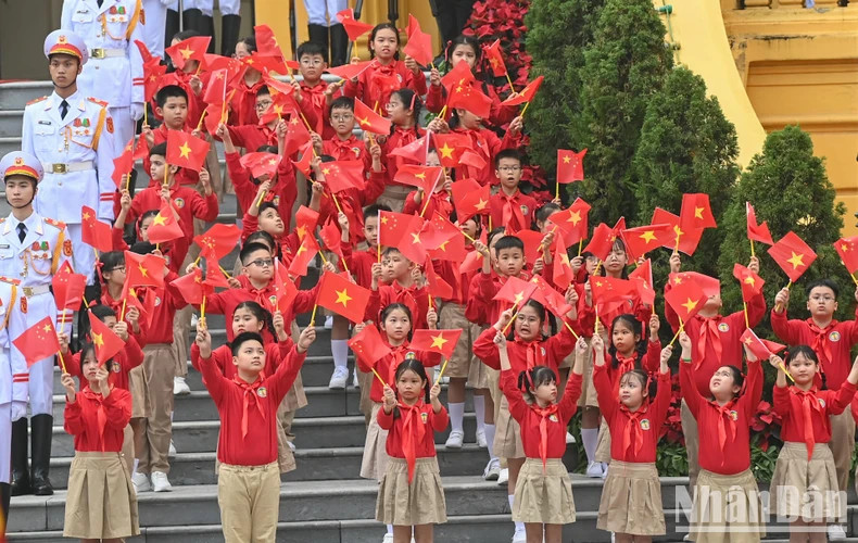 Students from the capital city of Hanoi welcome Party General Secretary Nguyen Phu Trong and his spouse and Chinese Party General Secretary and President Xi Jinping and his spouse.