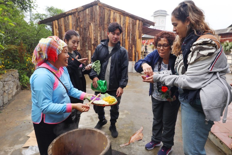 Visitors enjoy five-colour sticky rice in the cultural space of the Giay. (Photo: collaborator)