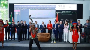 Prime Minister Pham Minh Chinh and delegates beat the drum to open a trading session at the Johannesburg Stock Exchange. (Photo: VNA)