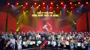 Party General Secretary To Lam and Minister of National Defence General Phan Van Giang pose for a photo with the award-winning authors and author groups. (Photo: VNA)