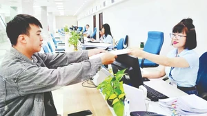 Officials of the Quang Ninh Provincial Public Administration Service Centre receive and process citizens’ dossiers. (Photo: Thanh Hoa)