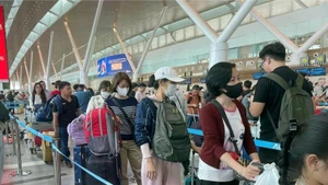 Passengers wait to handle boarding procedures at Tan Son Nhat International Airport. (Photo: VNA)