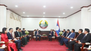 Lao Deputy Prime Minister and Minister of Foreign Affairs Thongsavan Phomvihane and Vietnamese Ambassador to Laos Nguyen Minh Tam at their meeting on March 23 (Photo: VNA)