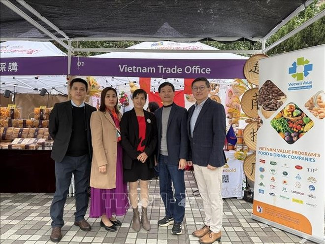 Vu Thi Thuy, Deputy Consul General and Trade Counsellor of Viet Nam in Hong Kong (second, left) and businesses participating in the expo (Photo: VNA)