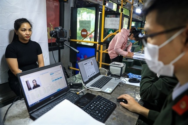 Police taking a picture of a woman for her ID card. (Photo: VNA) id-card.jpg