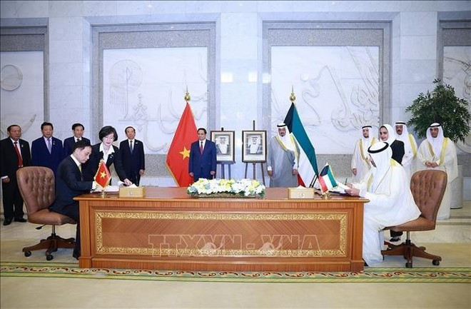 Prime Minister Pham Minh Chinh and his Kuwaiti counterpart Sheikh Ahmad Al-Abdullah Al-Sabah witness the signing of a protocol amending the Agreement on visa exemption for diplomatic and official passport holders between Viet Nam and Kuwait, and a memorandum of cooperation between the Diplomatic Academy of Viet Nam under Ministry of Foreign Affairs and the Saud Al-Nasser Al-Sabah Kuwait Diplomatic Institute under Kuwait’s Ministry of Foreign Affairs. (Photo: VNA)