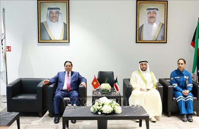 Prime Minister Pham Minh Chinh (left) meets with a leader of the Al-Zour Refinery (Photo: VNA)