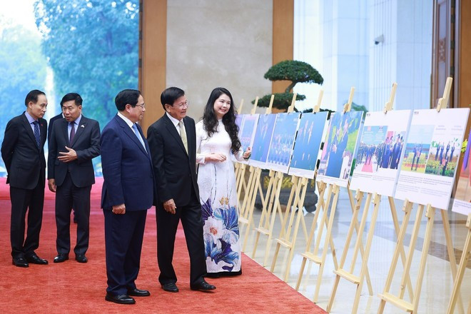 PM Pham Minh Chinh and General Secretary of the LPRP Central Committee and President of Laos Thongloun Sisoulith visit a photo display hosted by the Viet Nam News Agency. (Photo: VNA)
