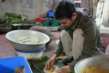 Nguyen Tat Lo, Thuy Duong village, wrapping chung cakes. (Photo: VNA)