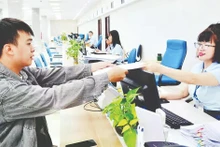 Officials of the Quang Ninh Provincial Public Administration Service Centre receive and process citizens’ dossiers. (Photo: Thanh Hoa)