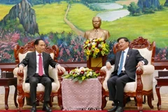 Minister of Foreign Affairs Le Hoai Trung (L), who is Special Envoy of General Secretary of the Communist Party of Viet Nam (CPV) Central Committee To Lam, meets with General Secretary of the LPRP Central Committee and President of Laos Thongloun Sisoulith. (Photo: VNA)