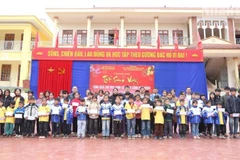 Representatives from various organisations present Tet gifts to 62 disadvantaged students at Chieng Ngan A Primary and Secondary School. (PHOTO: PHAN THAO)