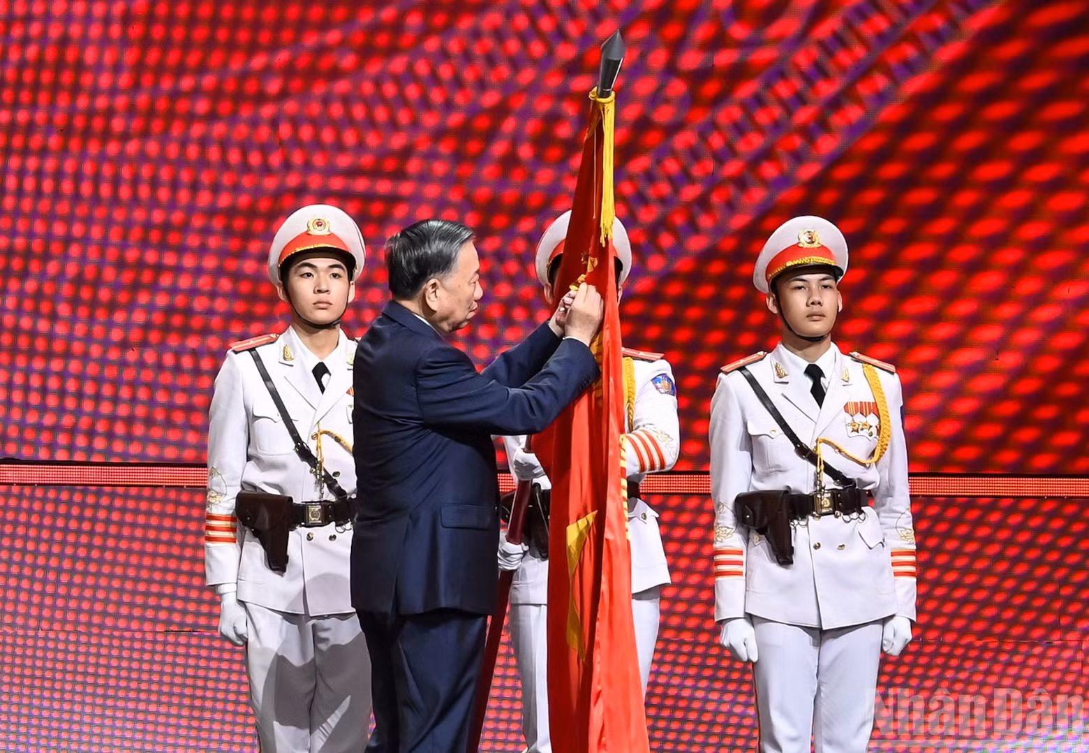 General Secretary and State President To Lam affixes the Gold Star Order to the traditional flag of the People's Security Force.