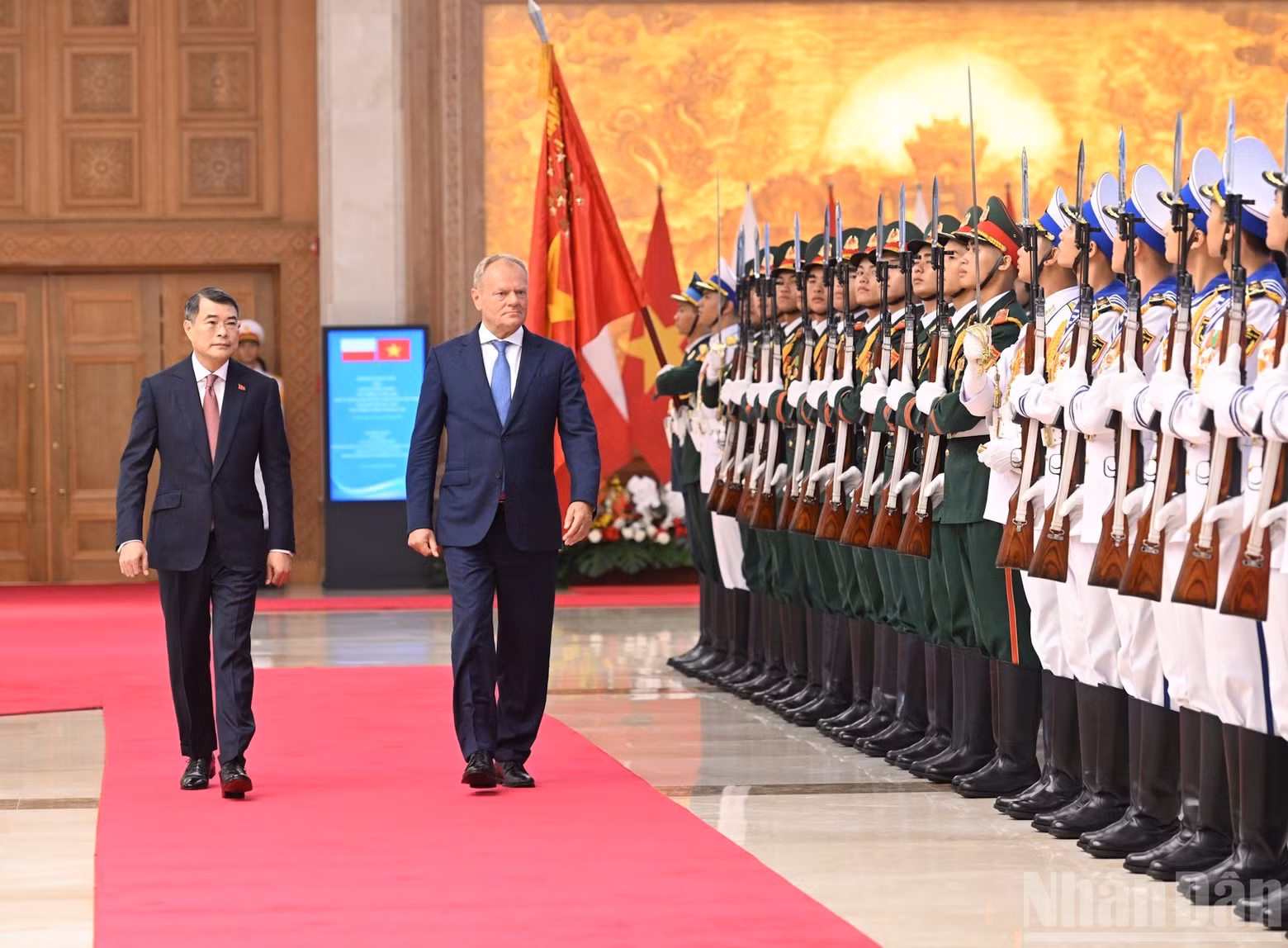 Prime Minister Le Minh Hung and Polish Prime Minister Donald Tusk review the honour guard of the Viet Nam People's Army.