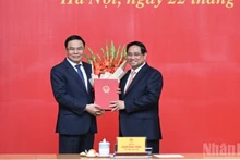 PM Pham Minh Chinh presents congratulatory flowers to Acting Minister of Industry and Trade Le Manh Hung. (Photo: NDO)