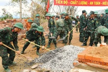 Soldiers of Military Region 5 work together to rebuild homes for residents affected by floods in Dak Lak Province. (Photo: Van Vien)
