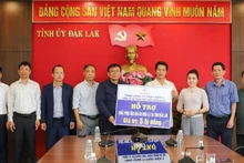 The working delegation presents a symbolic cheque for the relief funding to representatives of Dak Lak Province.