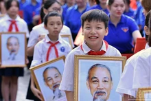 Students carried a portrait of President Ho Chi Minh at the flag-raising ceremony in Ha Noi