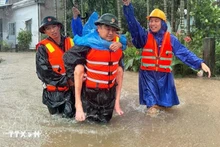 Military forces take a resident from a flooded area. (Photo: VNA)
