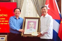 Deputy Prime Minister Ho Quoc Dung presents a portrait of President Ho Chi Minh to Ambassador Le Quang Long and staff of the Embassy. (Photo: Viet Nam Embassy in Cuba)