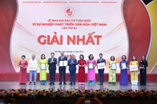 Deputy Prime Minister Mai Van Chinh and Minister of Culture, Sports and Tourism Nguyen Van Hung present first prizes to the winners. (Photo: NDO)