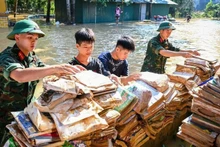 Soldiers and students drying books and school supplies at the Ethnic Boarding Secondary and High School of Huu Lung District, Lang Son Province. (Photo: THANH DAT)