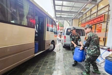 Military medical staff load Chloramin B – a water disinfectant chemical – onto a truck.