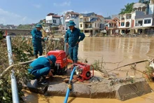 Militia forces operate water pumps to clean streets and schools in Thuc Phan Ward, Cao Bang Province. (Photo: Minh Tuan)