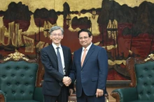 Prime Minister Pham Minh Chinh (R) welcomes Deputy Managing Director of the International Monetary Fund Kenji Okamura. (Photo: NDO)