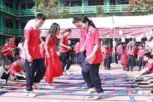 Schoolchildren join a bamboo pole dance at the festival