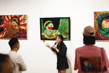 Phan Tu Tran presents her works to exhibition visitors (Photo courtesy of the artist)