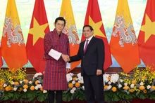 Prime Minister Pham Minh Chinh (R) welcomes King of Bhutan Jigme Khesar Namgyel Wangchuck in Ha Noi on August 19. (Photo: NDO)