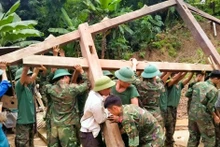 Officers and soldiers of the Tram Tau district armed forces help a poor household in Hat Luu commune build a new house. (Photo: thanhtra)