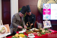 International friends experience how a bowl of pho is prepared. (Photo: NDO)