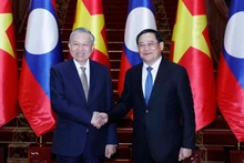 Party General Secretary To Lam (left) meets with Lao Prime Minister Sonexay Siphandone on February 5 in Vientiane. (Photo: VNA)