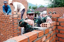 Soldiers of the Quang Ngai provincial Military Command build houses for residents in Tay Tra commune. (Photo: VNA)