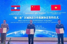 Representatives of Viet Nam, China and Laos sign the new trilateral law enforcement cooperation mechanism on March 25. (Photo: ANH DUNG)