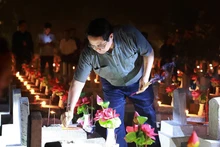 Prime Minister Pham Minh Chinh lights candles and incense to pay tribute to heroic martyrs at Truong Son National Martyrs' Cemetery. (Photo: VNA)