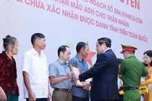PM Pham Minh Chinh presents the announcements of martyrs' DNA testing results to representatives of families at the conference on July 25. (Photo: VNA)