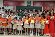 Ngo Phuong Ly presents Vietnamese books and storybooks to the children.