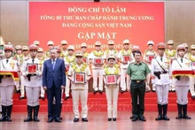 Party General Secretary To Lam and Minister of Public Security Gen. Luong Tam Quang present gifts to outstanding individuals from the People’s Public Security Force and grassroots-level security units, at the meeting. (Photo: VNA)