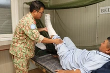 Dr Tran Duc Tai examines the patient after surgery. (Photo: TIEN PHUC)