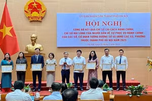 Vu Dai Thang, Chairman of the Ha Noi Municipal People’s Committee, presents certificates of merit to units with high rankings in administrative reform in 2025.