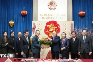 Vietnamese Ambassador Dang Minh Khoi and Lao Ambassador Shiphandone Oybuabuddy with officials and staff of the two embassies. (Photo: VNA)