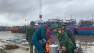 Border guard officers at Ky Ha Port Border Gate are assisting residents in securing their boats. (Photo: VNA)