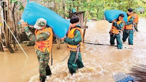 Officers and soldiers of the Dak Lak Provincial Military Command help people in Ea Sup commune move their assets to a safe place. (Photo: CONG LY)