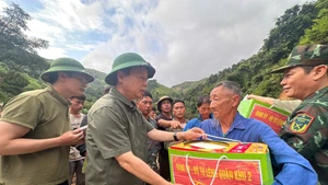 Deputy Prime Minister Tran Hong Ha presents gifts and encourages people affected by natural disasters in Hang Pu Xi village, Xa Dung commune, Dien Bien province. 
