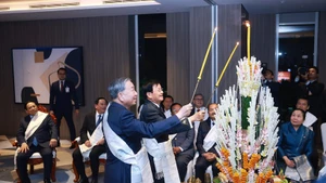 Party General Secretary To Lam (right) and Lao Party General Secretary and President Thongloun Sisoulith take part in Laos’ traditional wrist-tying ceremony on February 5. (Photo: VNA)