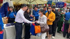 Representatives of the Organising Committee present gifts and lucky money to people before their departure home for Tet (Lunar New Year).